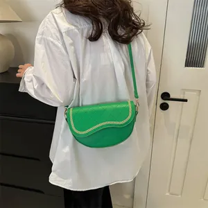Détail du sac de selle matelassé vert avec chaîne dorée et bandoulière réglable