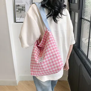 Detail of pink and white checkered canvas tote bag with EMIS logo and blue shoulder strap