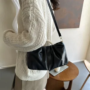 Détails du sac plissé noir avec anse en perles et texture en cuir synthétique souple