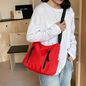 Grand sac cabas rouge en nylon avec deux poches zippées et bandoulière noire pour le quotidien