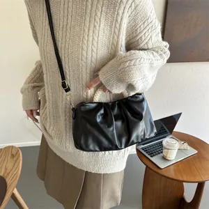 Détail du sac nuage noir plissé avec poignée en perles et fine bandoulière amovible