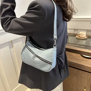 Detail view of denim hobo bag featuring silver zippers and adjustable shoulder strap
