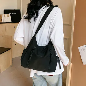 Détail du sac cabas en nylon noir avec fermetures éclair et tirettes tressées