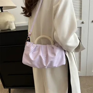 Détail du sac nuage lilas avec poignée en perles et plis texturés vus de profil