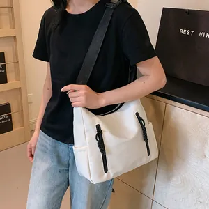 Détail du sac fourre-tout blanc en nylon avec zips verticaux et large bandoulière noire