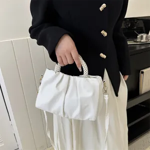 Détail du sac nuage plissé blanc avec poignée en perles et finitions métalliques dorées
