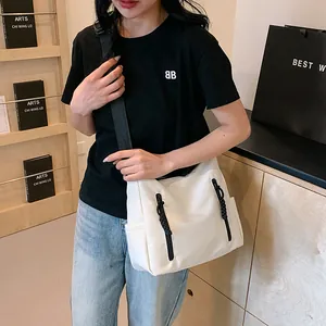 Détail du sac fourre-tout en nylon blanc avec double zip et tirettes tressées