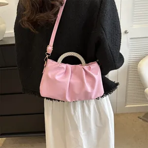 Détail du sac nuage plissé rose clair avec poignée en perles et bandoulière réglable amovible