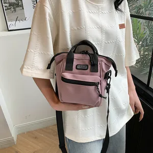 Detail of dusty rose canvas shoulder bag with front zip pocket and adjustable strap