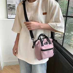 Pink canvas crossbody backpack for women with black straps and zippered front pocket