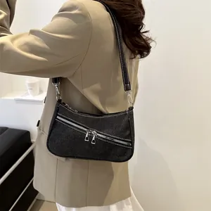 Chic black denim shoulder bag with silver zippers and adjustable strap for urban style