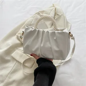 Détail du sac nuage plissé blanc avec poignée en perles élégante et texture cuir fin