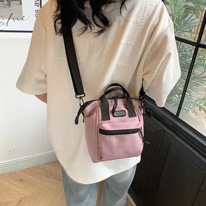 Detailed close-up of a pink canvas crossbody bag with S Sport logo and black strap