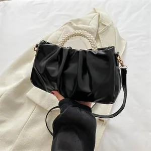 Détail du sac nuage noir plissé avec poignée en perles et garnitures dorées
