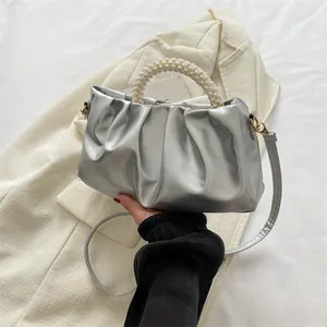Gros plan du sac nuage argenté plissé avec anse en perles et boucles dorées chic