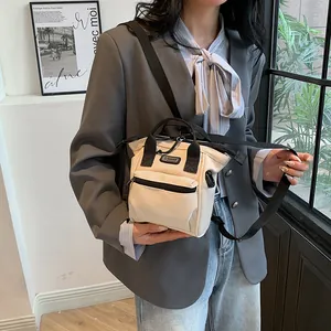 Mini canvas crossbody bag in beige and black with SPORT logo shown on model
