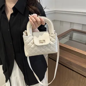 Close-up of quilted cream shoulder bag with golden twist lock and circular handle detail