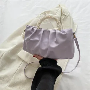 Gros plan sur le sac nuage plissé lilas avec poignée en perles et bandoulière