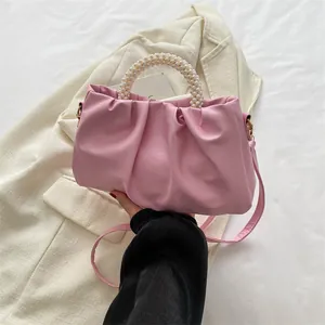 Détail du sac nuage froncé rose avec une poignée élégante en perles d'imitation