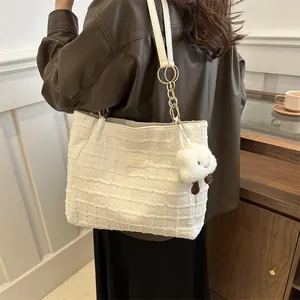 Dettaglio borsa tote trapuntata panna con catena dorata e ciondolo a nuvola soffice