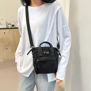 Detail of a black canvas crossbody bag featuring front zipper pocket and SPORT logo