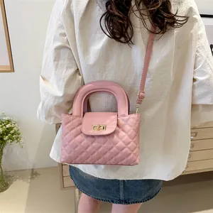 Close-up of pink quilted crossbody bag featuring golden lock and elegant leather texture