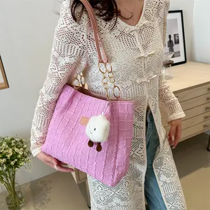 Dettaglio della borsa tote rosa trapuntata con ciondolo peluche e tracolla dorata