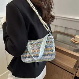 Close-up of contrast woven shoulder bag with butterfly embroidery and pearl chain strap