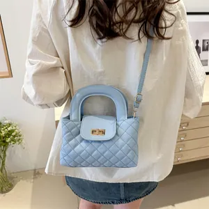 Detail of light blue quilted chain bag with gold twist lock on a female model