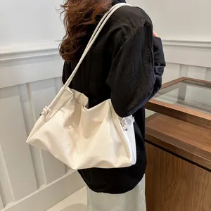 Minimalist white leather tote bag with drawstring detail and embossed letters