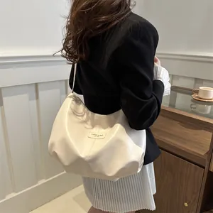 Detail of white Hobo shoulder bag with vertical stitching and metal brand logo