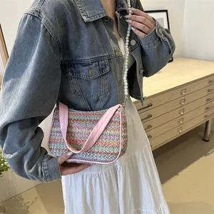 Detail of colorful woven shoulder bag with butterfly embroidery and pearl strap