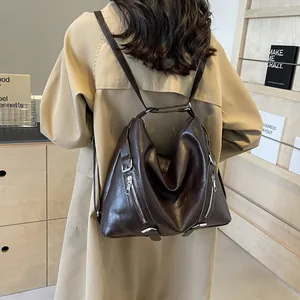 Rear view of a vintage dark brown leather backpack on model wearing a khaki trench coat