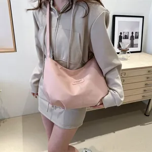 Detail of pink nylon shoulder bag showing smooth fabric texture and fashion label