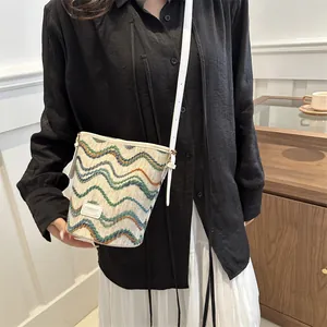 Chic woven bucket bag with wave patterns and leather strap worn by a model