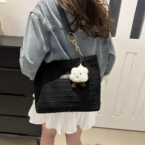 Dettaglio della trama di una borsa tote nera trapuntata con ciondolo a nuvola
