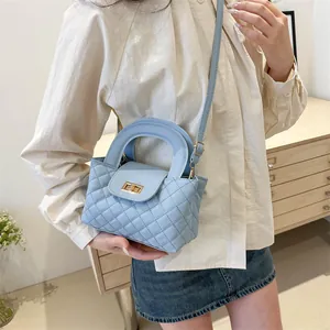 Light blue quilted leather handbag with gold metal lock and circular handle for women