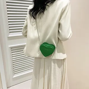 Détail d'un mini sac à bandoulière émeraude en forme de cœur avec chaîne argent