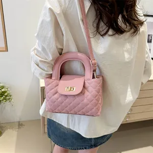 Pink quilted crossbody bag with gold twist lock and top handle shown in a daily setting