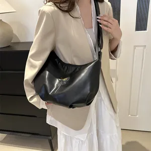 Detail of soft black leather hobo bag featuring golden Fashion & Bag lettering on the front