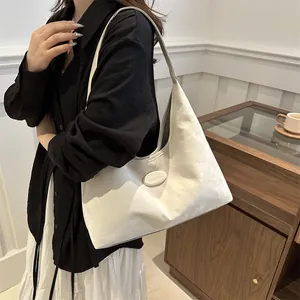 Moderne beige Hobo-Tasche von Model getragen, idealer Stil für das Frühjahr im schicken Design