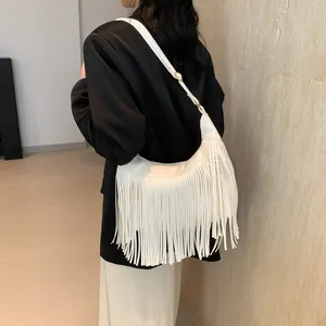 Sac hobo blanc à longues franges avec bandoulière réglable porté par un mannequin