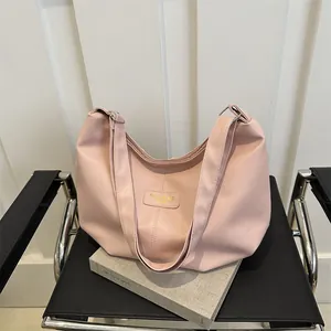 Detailed view of pink faux leather shoulder bag with Fashion & Bag embossed label