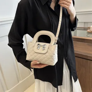Chic quilted beige handbag with bow hardware detail shown on a model for lifestyle view