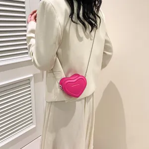 Mini sac bandoulière en forme de cœur rose fuchsia avec une élégante chaîne argentée