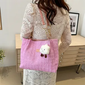 Borsa tote rosa trapuntata con catena dorata e ciondolo a nuvola indossata da modella