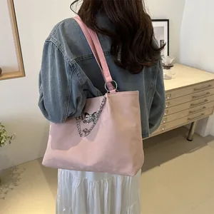 Pink minimalist large capacity tote bag with silver metal charms and chain on a shoulder bag