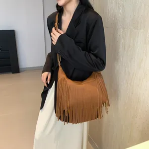 Sac bandoulière bohème marron porté par un mannequin avec de longues franges