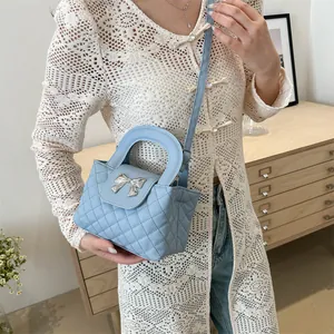 Quilted light blue handbag with silver bow metal clasp and adjustable shoulder strap