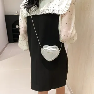 Détail du mini sac cœur avec texte doré sur cuir PU argenté métallique et chaîne